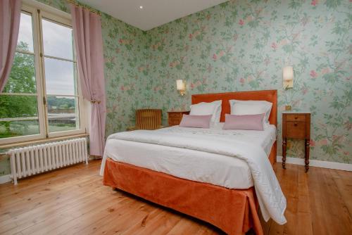 a bedroom with a large bed with pink pillows at Domaine du Chateau Vert in Hondainville