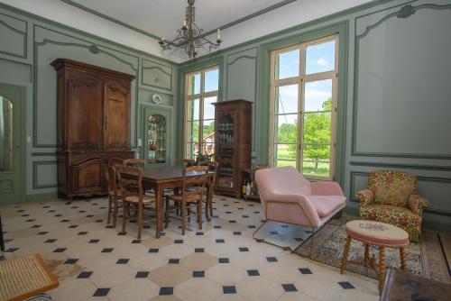 a living room with a table and chairs at Domaine du Chateau Vert in Hondainville