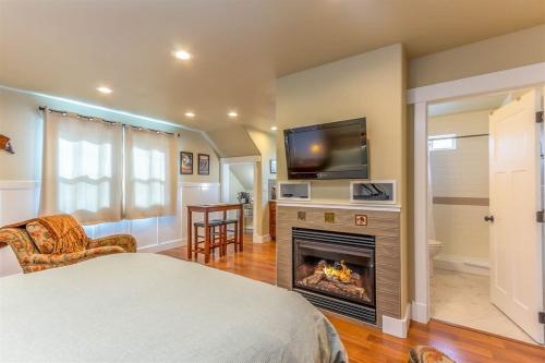 a bedroom with a bed and a fireplace with a television at Cumberland Bungalow walking distance to downtown in Bend