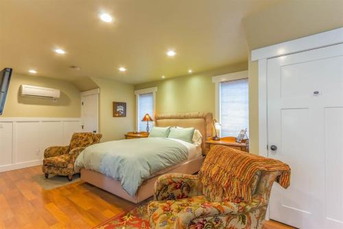 a bedroom with a bed and two chairs at Cumberland Bungalow walking distance to downtown in Bend