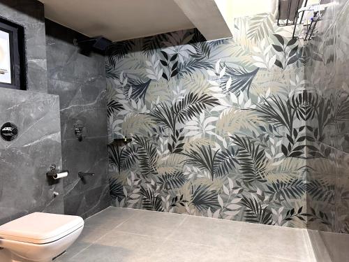 ササン・ギルにあるHotel Anil Farmhouse Gir Jungle Resortの黒と白の壁紙のバスルーム(トイレ付)