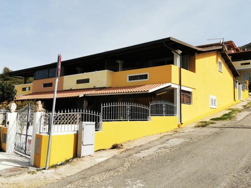 un bâtiment jaune sur le côté d'une rue dans l'établissement La Casa Di Angelo, à Tresnuraghes