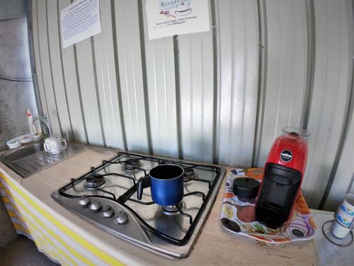 encimera de cocina con fogones y cafetera en Gole Alcantara mini Glamping Lanternavacanze, en Motta Camastra