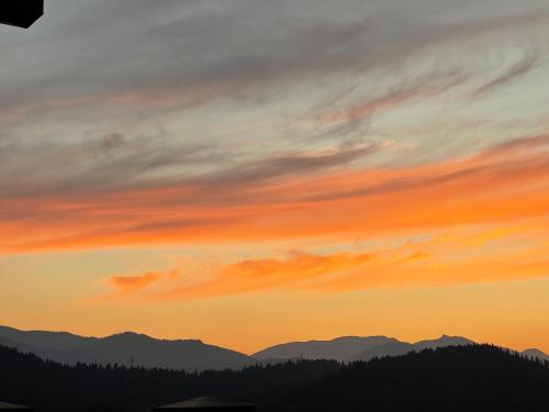 a sunset with mountains in the background at THE BEST at SUNCADIA LODGE - EXECUTIVE RIVER VIEW SUITE in Cle Elum