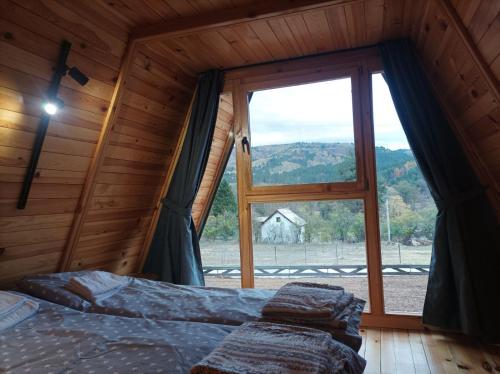 a bedroom with a bed and a large window at Vila Isidora in Berovo