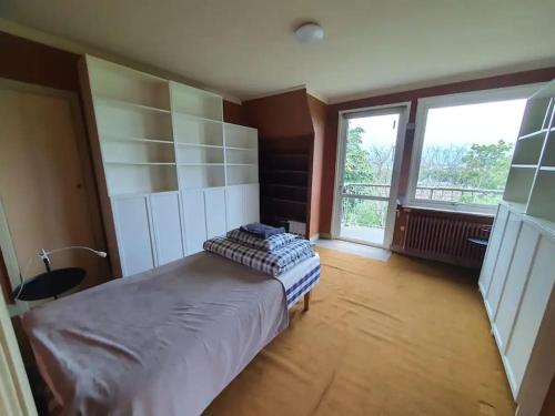 1 dormitorio con cama y ventana grande en Lisebergs lyx Villa / Svenska Mässan / Ullevi, en Gotemburgo