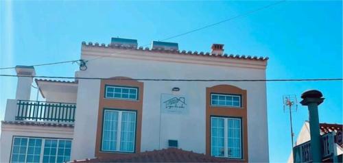 a large white building with windows on the side of it at Lugar do Sonho Guest House in Cercal