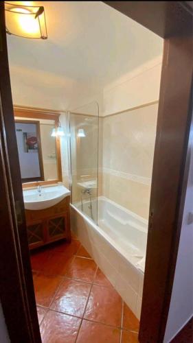 a bathroom with a bath tub and a sink at Lugar do Sonho Guest House in Cercal