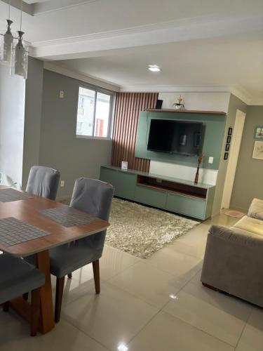 uma sala de estar com uma mesa de jantar e uma televisão em Belíssimo apartamento a 01 km da litorânea em São Luís