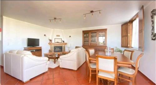 a living room with white furniture and a table at Lugar do Sonho Guest House in Cercal
