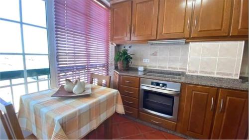 una cucina con un tavolo e una stufa forno superiore di Lugar do Sonho Guest House a Cercal