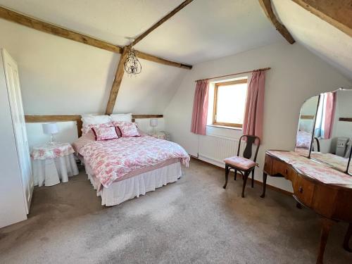 a bedroom with a bed and a mirror at Dairy Cottage in Cockley Cley