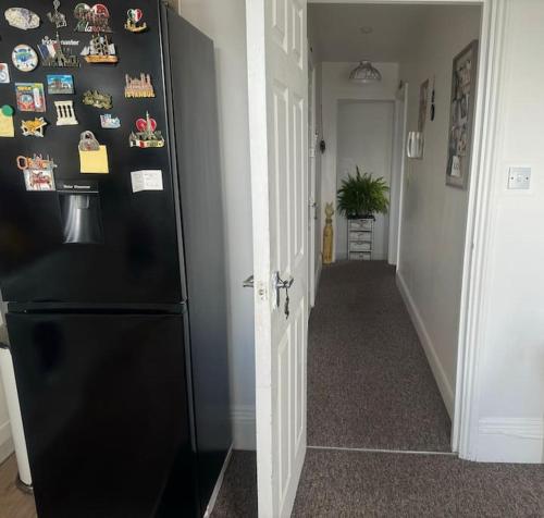 a black refrigerator in a room with a hallway at Comfy entire place for max 4. in London