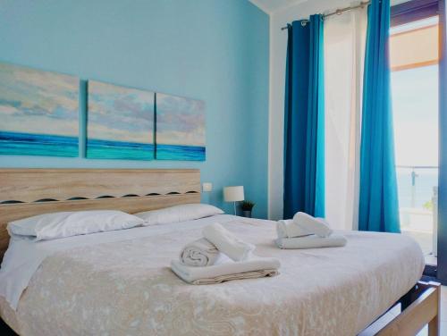 a bedroom with a large bed with towels on it at Red Luxury in Borgo Guardiola near Cefalù in Mandra Capreria