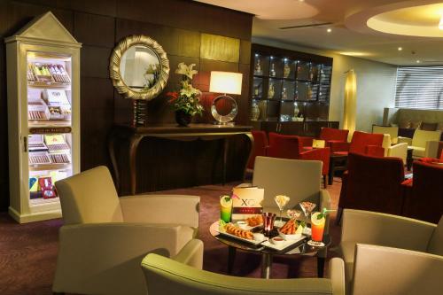 a restaurant with a table and chairs and a mirror at Mövenpick Hotel Casablanca in Casablanca