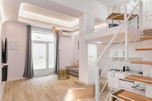 Apartamento blanco con escalera y sala de estar. en Apartamento lujoso cercano al centro de Madrid en Madrid