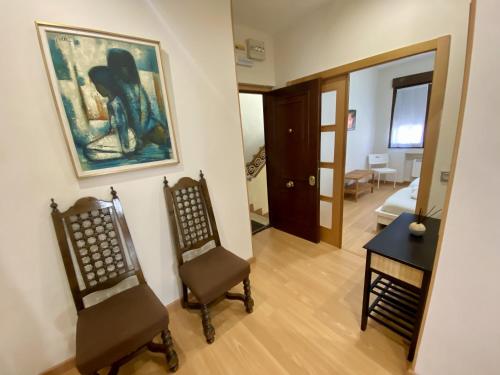 ein Wohnzimmer mit 2 Stühlen und einem Gemälde an der Wand in der Unterkunft Apartamento Mar Bella in Llastres
