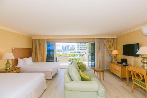 ein Hotelzimmer mit 2 Betten und einem Sofa in der Unterkunft Ilikai Tower 333 Yacht Harbor View 1BR in Honolulu