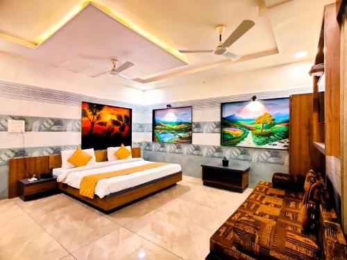 ササン・ギルにあるHotel Anil Farmhouse Gir Jungle Resortの大きなベッドが備わるベッドルーム1室、壁に絵画が飾られています。
