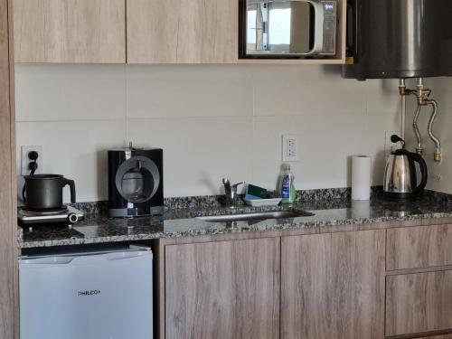 a kitchen with a sink and a stove top oven at Velvet Apart in Esperanza