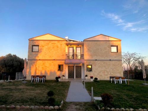 une maison avec des tables et des chaises devant elle dans l'établissement Delight House's, à Afytos