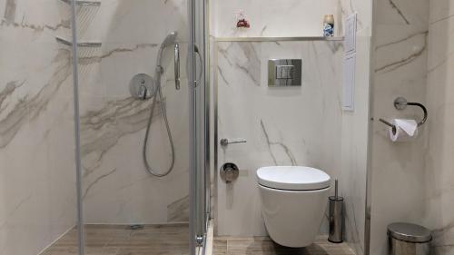 a white bathroom with a shower and a toilet at Lux 2 Central Apartment with Garage in Plovdiv