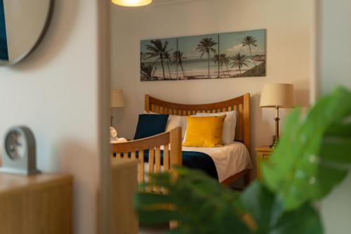 1 dormitorio con 1 cama con almohadas amarillas y azules en The Bay Retreat, en Cardiff