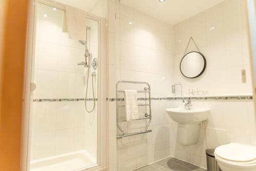 a bathroom with a shower and a toilet and a sink at The Bay Retreat in Cardiff