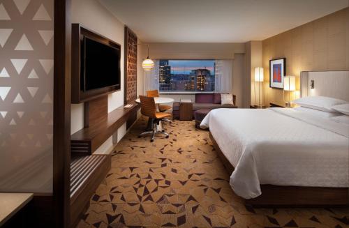 a hotel room with a bed and a television at Sheraton Grand Seattle in Seattle