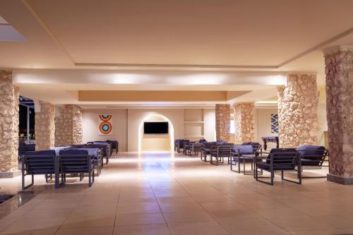 a large room with rows of chairs and tables at Pickalbatros Vita Resort - Portofino Marsa Alam in Abu Dabab
