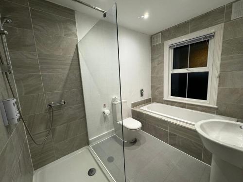 a bathroom with a shower and a toilet and a sink at Galaxy apartments Brentwood in Brentwood