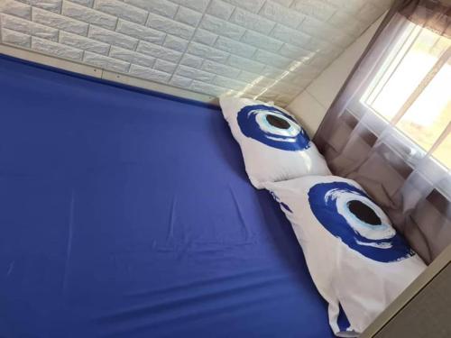 een bed met blauwe en witte kussens erop bij שאשא קראון in Eilat