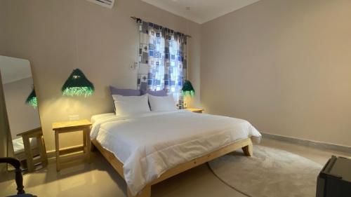 une chambre avec un grand lit blanc avec une fenêtre dans l'établissement Hanaia House, à Stone Town