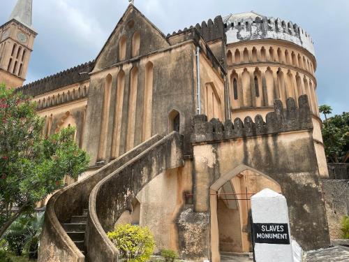 un ancien bâtiment avec un escalier menant à une église dans l'établissement Hanaia House, à Stone Town
