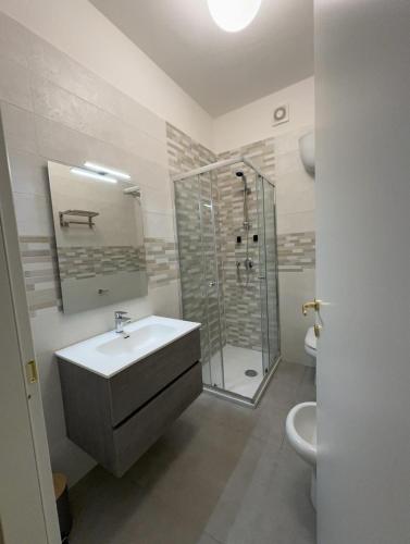 a white bathroom with a sink and a shower at 4Th Floor Caserta in Caserta