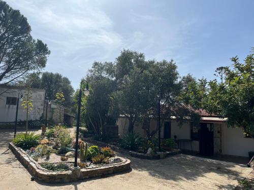a house with a courtyard with plants and trees at GardenRocks in Fluminimaggiore