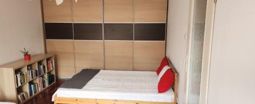 a small bed in a room with a book shelf at Nature in Kraków