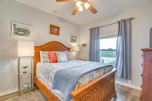 um quarto com uma cama de madeira e uma janela em Gulf Shores Condo with Balcony 2 Mi to Fort Morgan! em Gulf Shores