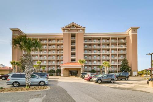 a large hotel with cars parked in a parking lot at Gulf Shores Condo with Balcony 2 Mi to Fort Morgan! in Gulf Shores