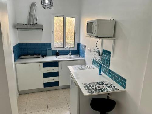a kitchen with a sink and a microwave at Caloura Water Accommodation in Lagoa