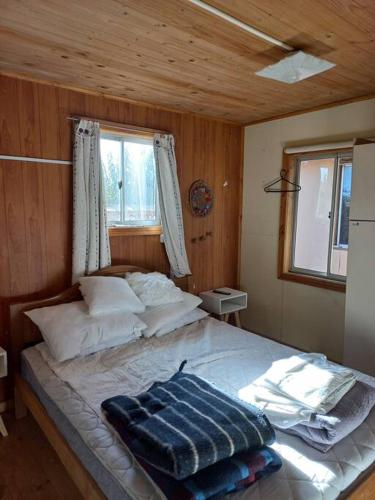 um quarto com uma cama num quarto de madeira em Pichilemu, a 200mts de la playa. em Pichilemu