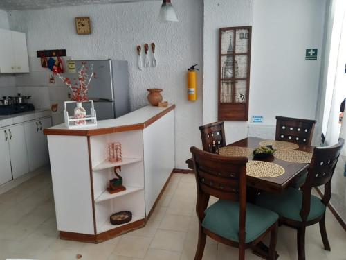 a kitchen with a table and a kitchen with a refrigerator at Edificio Santa Catalina in San Andrés