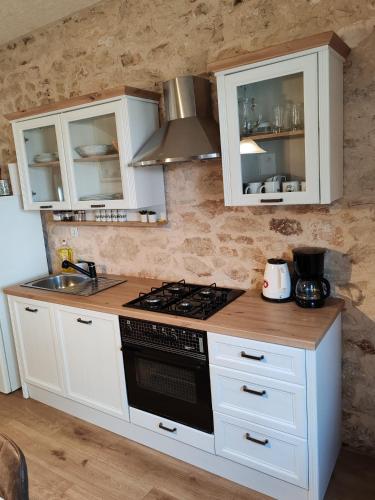 a kitchen with white cabinets and a stove top oven at Šimun&Jakov in Drinovci