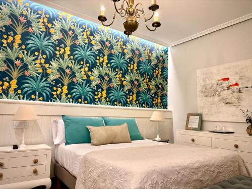 a bedroom with two beds and a large painting on the wall at El Patio de los Jazmines Boutique-House in Consuegra