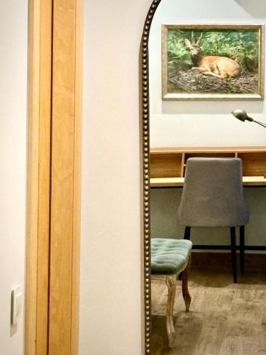 a mirror in a room with a chair and a picture at El Patio de los Jazmines Boutique-House in Consuegra