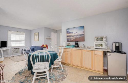 a kitchen and dining room with a table and chairs at Tomoka River Guest House in Ormond Beach