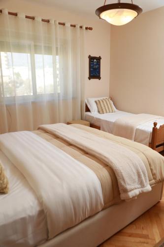 a bedroom with two beds and a window at Central Fortuzi Apartment in Tirana