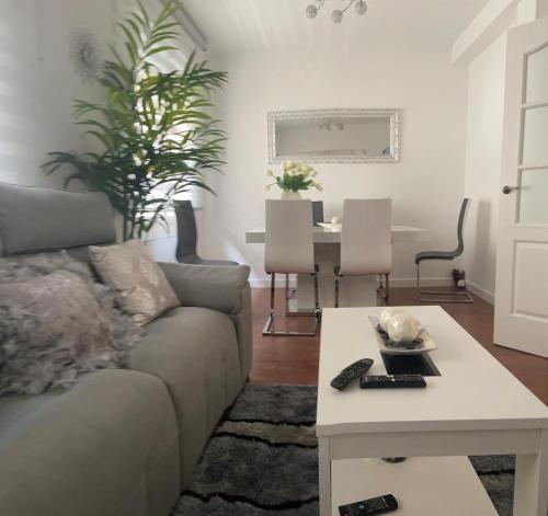 uma sala de estar com um sofá e uma mesa em Apartamento Ferrer Gutierrez II em Barbastro