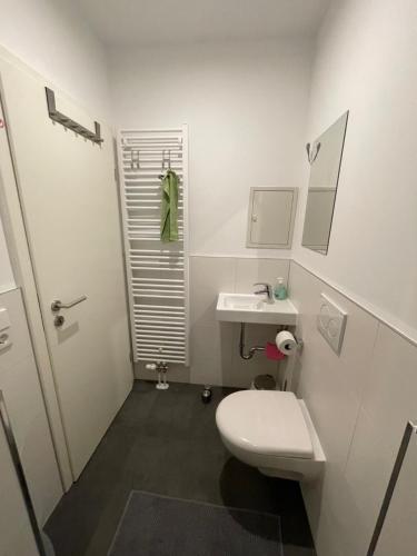 a white bathroom with a toilet and a sink at Leipzig-in in Leipzig