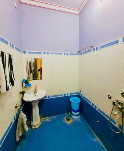 a bathroom with a white sink and a blue floor at The Desert Palace in Bikaner
